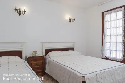 a bedroom with two beds and a window at Akivillas Quarteira Rose in Quarteira