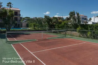 a tennis court with a net on top of it at Akivillas Quarteira Rose in Quarteira