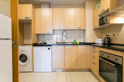 a kitchen with wooden cabinets and white appliances at Quinta da Barracuda by Golden Zenith in Albufeira