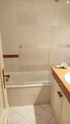 a bathroom with a shower and a white tub at Marina Vilamoura Apartment in Vilamoura