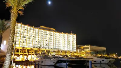 a large hotel with boats in a marina at night at Marina Vilamoura Apartment in Vilamoura
