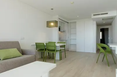 a living room with a couch and a table and chairs at 3HB Falésia Garden in Albufeira