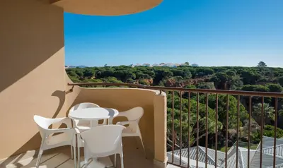 a balcony with a table and chairs and a view at 3HB Falésia Garden in Albufeira