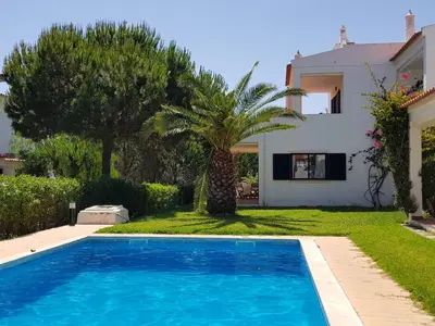 a villa with a swimming pool in front of a house at Algarve Apartment Falésia in Albufeira