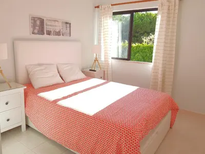 a bedroom with a bed with a red and white blanket at Algarve Apartment Falésia in Albufeira