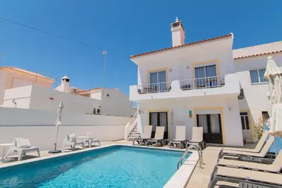 a villa with a swimming pool and a house at Apartments Salomé in Albufeira