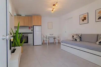 a large living room with a couch and a kitchen at Apartments Salomé in Albufeira