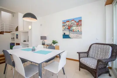 a dining room with a white table and chairs at Villa Granada in Almancil