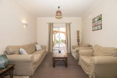 a living room with two couches and a table at Villa Anita in Quarteira