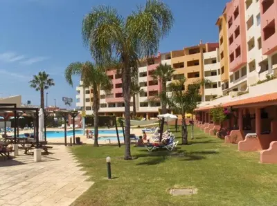 a resort with a pool and palm trees and buildings at Bellavista Ténis Clube - Studio Sea View in Albufeira