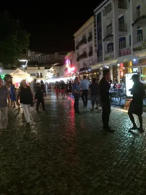 a group of people walking down a street at night at Bellavista Ténis Clube - Studio Sea View in Albufeira