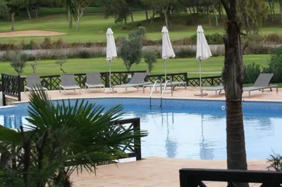 a swimming pool with chairs and umbrellas at Quinta Formosa - Villas in Quinta do Lago