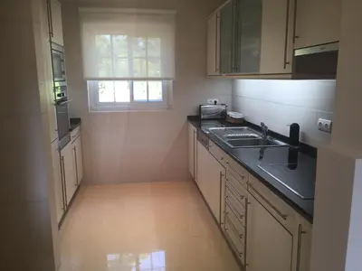a kitchen with white cabinets and a sink and a window at Quinta Formosa - Villas in Quinta do Lago