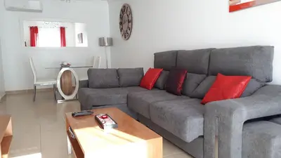 a living room with a gray couch and red pillows at Albufeira Lovely new Apartment W/ Pool in Albufeira