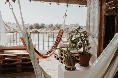 a hammock on a balcony with potted plants at Casa da Madalena Backpackers Hostel in Faro