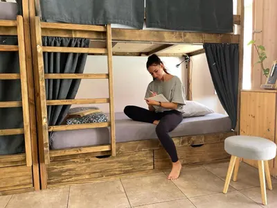 a woman sitting on a bed in a bunk bed at Casa da Madalena Backpackers Hostel in Faro