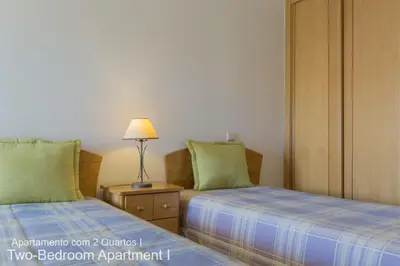 a bedroom with two beds and a lamp on a night stand at Akisol Vilamoura Nature in Vilamoura