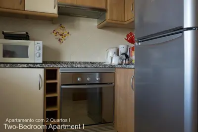a kitchen with a stainless steel refrigerator and a microwave at Akisol Vilamoura Nature in Vilamoura
