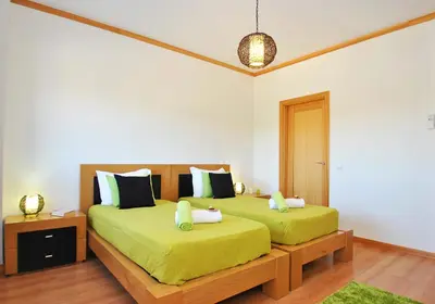 a bedroom with two beds with green sheets at Townhouse Mar 1 by Algarve Vacation in Albufeira