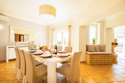 a kitchen and dining room with a table and chairs at Villa Florença by Algarve Vacation in Albufeira