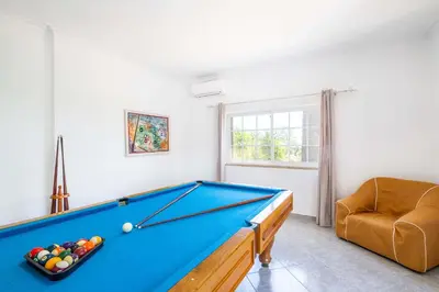 a living room with a pool table and a chair at Villa Valentina by Algarve Vacation in Almancil