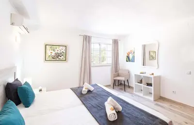 a bedroom with a large bed with blue pillows on it at Villa Valentina by Algarve Vacation in Almancil