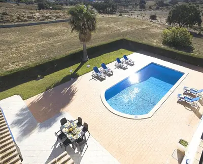 an overhead view of a swimming pool with chairs and a palm tree at Villa Sardenha by Algarve Vacation in Guia