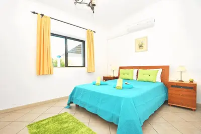a bedroom with a blue bed with a window at Villa Martinica by Algarve Vacation in Guia