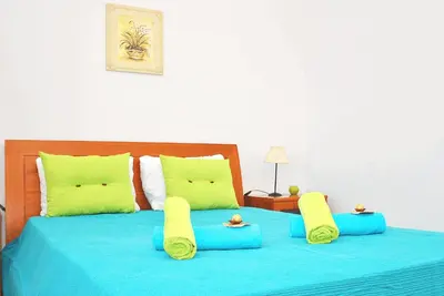 a large bed with blue sheets and yellow pillows at Villa Martinica by Algarve Vacation in Guia