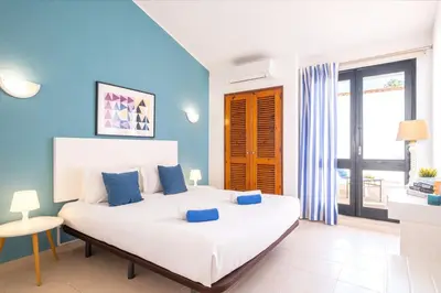a bedroom with a large white bed with blue walls at Villa Belize by Algarve Vacation in Albufeira