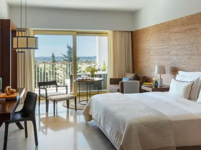 a hotel room with a large bed and a balcony at Victoria Golf Resort and Spa Managed by Accor in Vilamoura