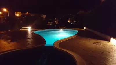 a swimming pool at night with blue lights at Olhos do Mar in Albufeira