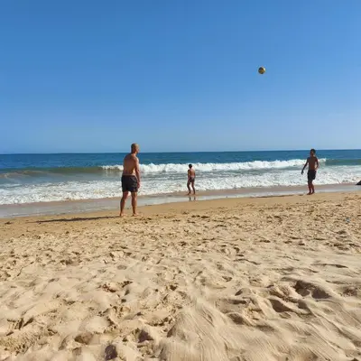 a group of people standing on the beach at Olhos do Mar in Albufeira