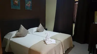 two beds with a swan sitting on top of them at Almancil Hostel in Almancil