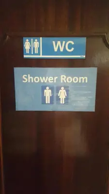 a sign on the door of a shower room at Almancil Hostel in Almancil