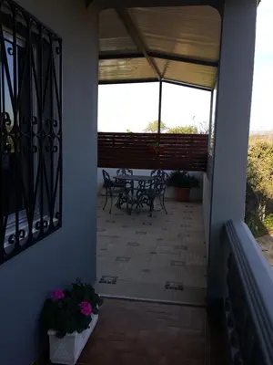a patio with a table and chairs on a porch at Almancil Hostel in Almancil