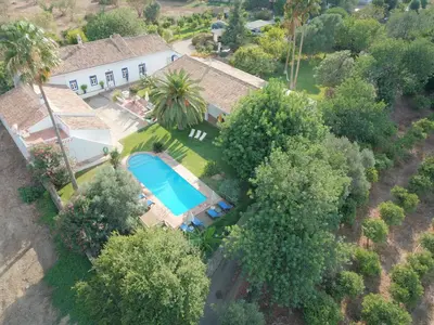 an overhead view of a house with a swimming pool and trees at Quinta Quinze in Boliqueime
