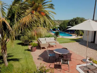 a patio with a table and chairs and a pool at Quinta Quinze in Boliqueime