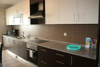 a kitchen with white cabinets and a blue plate on the counter at Edifice Ibérico in Albufeira