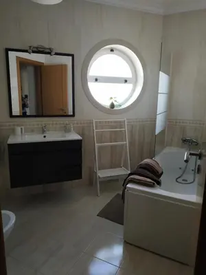 a bathroom with a tub and a sink and a mirror at Edifice Ibérico in Albufeira