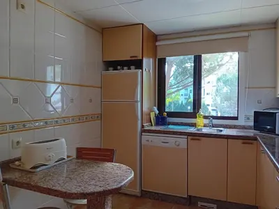 a small kitchen with a table and a refrigerator at Apartamento Falesia 6 B in Albufeira