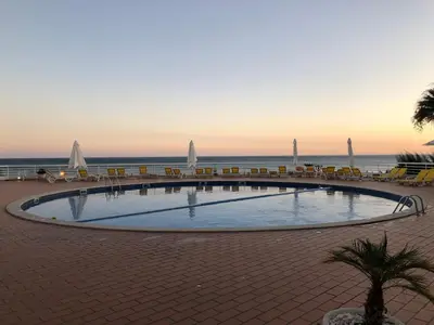 a swimming pool with chairs and the ocean in the background at Borda d`Água, Praia da Oura in Albufeira
