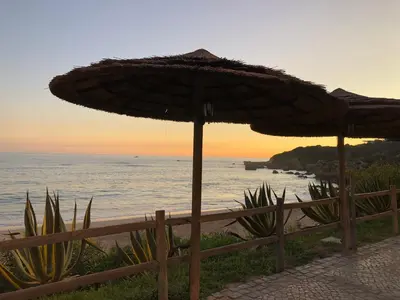 two umbrellas on a beach with the ocean at Borda d`Água, Praia da Oura in Albufeira