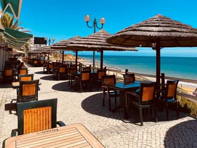 a group of tables and chairs with umbrellas on the beach at Borda d`Água, Praia da Oura in Albufeira