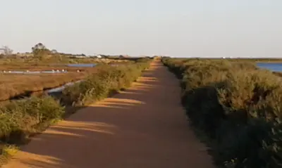 a dirt road next to a body of water at Rooms_Heart Apartment in Faro