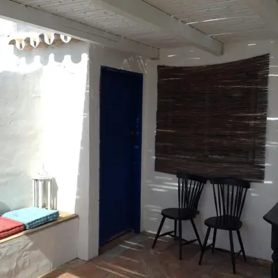 a room with two chairs and a blue door at Casa da Esperança – Rural and beach Villa in Algarve in Boliqueime