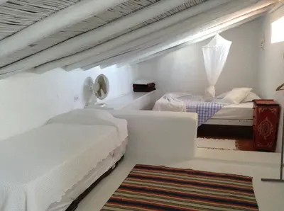 a white room with two beds and a rug at Casa da Esperança – Rural and beach Villa in Algarve in Boliqueime