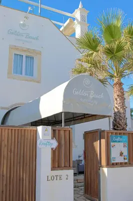 a bedroom with a bed with a view of the ocean at Golden Beach Guest House & Rooftop Bar in Faro