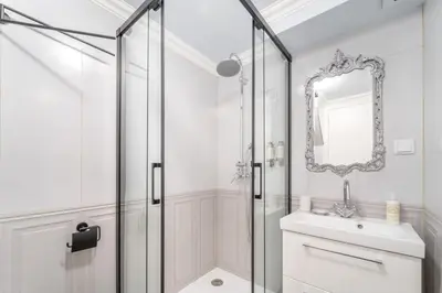 a bathroom with a shower and a sink and a mirror at Main Street Apartments by Raspberry Cascade in Faro