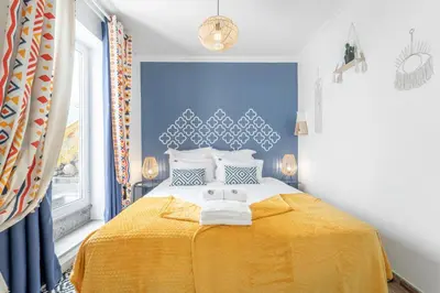 a bedroom with a yellow bed with a blue wall at Main Street Apartments by Raspberry Cascade in Faro